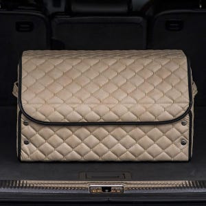 May include: Beige quilted storage organizer with black trim, sitting in the back of a car.
