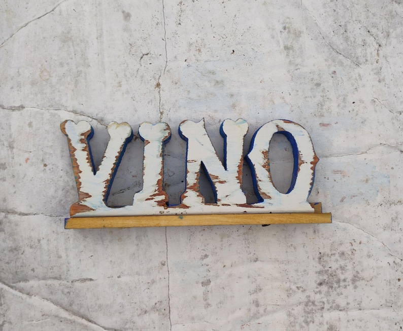 May include: White wooden letters spelling "VINO" with blue trim, mounted on a wooden base.
