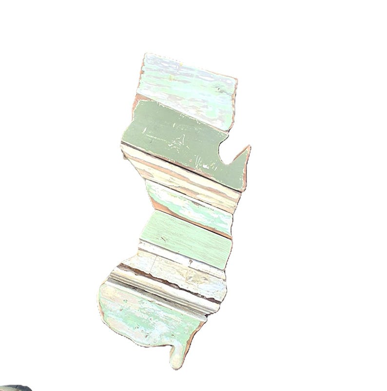 May include: Wooden wall art in the shape of New Jersey. The artwork is made of distressed wood planks in shades of green, white, and brown. The state outline is visible against a white background.
