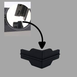 May include: Black plastic corner protector with a textured surface. The protector is designed to be used on furniture or other objects to prevent damage.