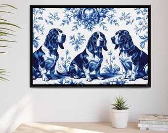May include: A framed print featuring three Basset Hound dogs in a blue and white floral design. The dogs are depicted in a seated position, with a classic blue and white color scheme. The artwork is displayed on a white wall.