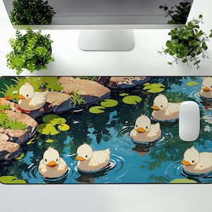 May include: A rectangular mousepad featuring an illustration of a pond scene with cartoon ducks swimming in blue water. The ducks are white with orange beaks. Green lily pads and rocks are also visible.