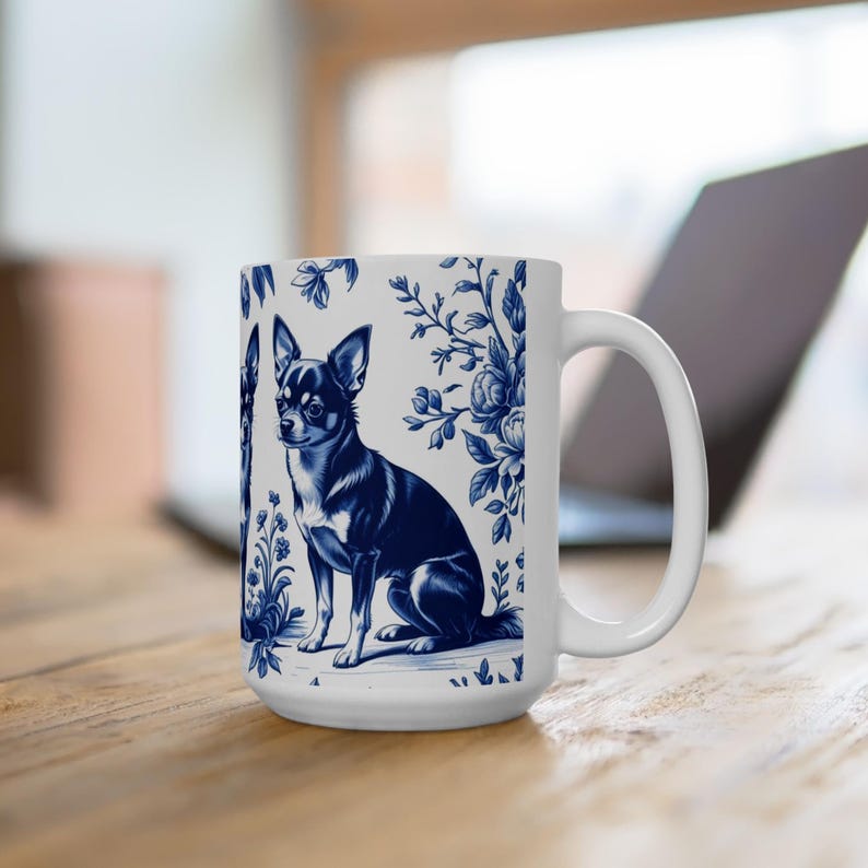 May include: White ceramic mug with a blue and white illustration of a Chihuahua dog and floral patterns. The mug has a large handle and a straight rim. The design is reminiscent of classic blue and white porcelain.