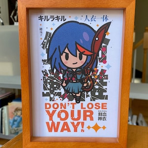 May include: A framed print featuring a cartoon character with blue hair and a red sword. The character is wearing a school uniform and is surrounded by colorful splatters. The text "DON'T LOSE YOUR WAY!" is printed below the character. The text "キルラキル 斬血 神衣" is printed in Japanese below the text.