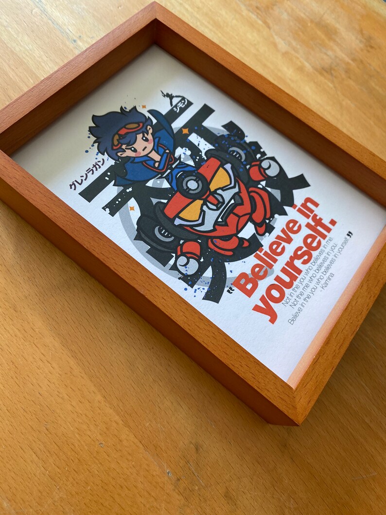 K&ouml;nnte beinhalten: Ein gerahmter Druck mit einer Cartoon-Illustration einer Figur in einem roten und gelben Roboter. Der Druck hat einen wei&szlig;en Hintergrund mit schwarzem Text, der lautet: "Glaube an dich selbst. Nicht an das Ich, das an dich glaubt. Nicht an das Du, das an mich glaubt. Glaube an das Du, das an dich selbst glaubt" - Kamina.