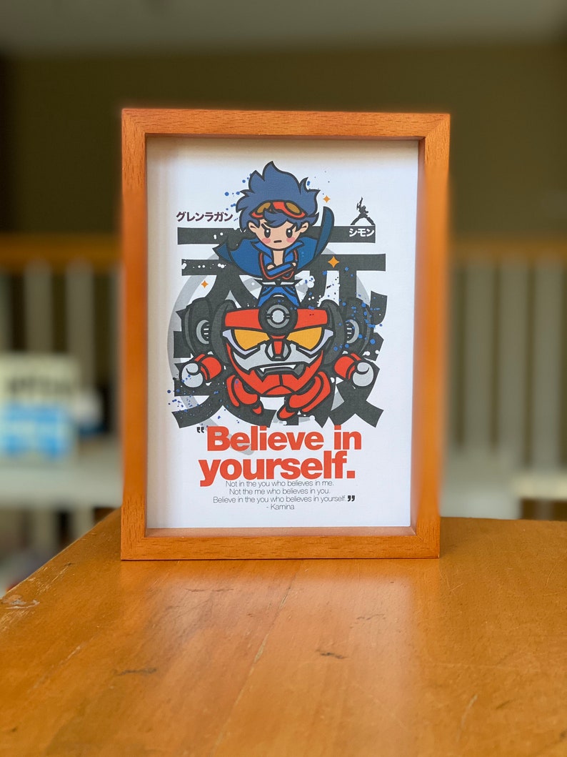 K&ouml;nnte beinhalten: Ein gerahmter Druck mit einer Cartoon-Illustration eines Roboters und einer Figur aus der Anime-Serie Gurren Lagann. Der Druck hat einen wei&szlig;en Hintergrund mit schwarzen und roten Akzenten. Der Text "Glaube an dich selbst." ist unter der Illustration gedruckt. Das Zitat wird Kamina zugeschrieben.