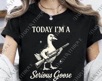 Op de afbeelding: Zwart T-shirt met de tekst "TODAY I'M A Serious Goose" en een afbeelding van een gans met een geweer. De gans is wit met zwarte details. De tekst is in witte, vette letters. Een humoristisch ontwerp voor vrijetijdskleding.