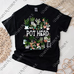 Puede incluir: Camiseta negra con un diseño blanco de plantas en macetas y el texto "POT HEAD". El diseño incluye una variedad de plantas, como cactus y suculentas, dispuestas en un patrón circular, creando un tema botánico.