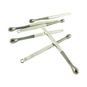 Pode incluir: Um conjunto de cinco ferramentas de metal prateado e preto com pontas arredondadas. As ferramentas estão dispostas em forma de cruz.