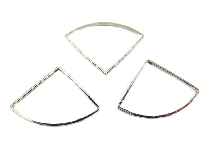 May include: Three silver-colored, open-backed, fan-shaped metal jewelry components. Each piece has a curved top and two straight sides, forming a geometric design. The components are displayed against a white background.