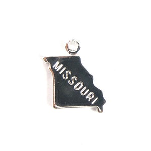 Könnte beinhalten: Silberner Anhänger in Form des Bundesstaates Missouri mit der Aufschrift "MISSOURI".