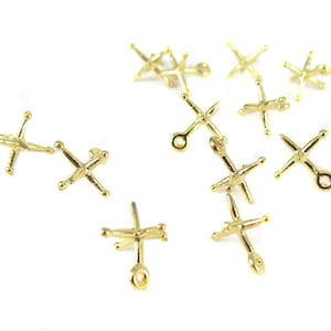 May include: A collection of ten gold-toned metal charms shaped like a star with five points. Each charm has a small loop at the top for attaching to a necklace, bracelet, or other jewelry.