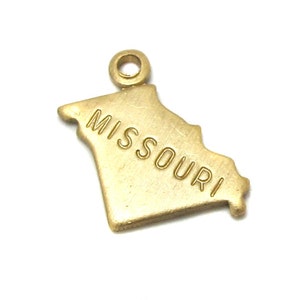 Könnte beinhalten: Goldfarbener Metallanhänger in Form des Bundesstaates Missouri mit der Aufschrift "MISSOURI" auf dem Anhänger.
