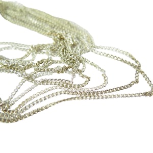 Puede incluir: Primer plano de un montón de cadenas plateadas, mostrando los intrincados detalles de los eslabones.