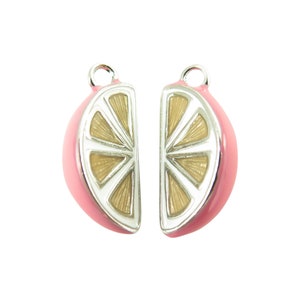 May include: Two silver charm pendants shaped like pink lemon slices. Each charm has a silver outline and a detailed yellow lemon design.