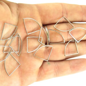 May include: Silver-toned metal geometric charms in various shapes, including triangles, squares, and curved segments. The charms are small and delicate, suitable for jewelry making or craft projects.