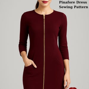Könnte beinhalten: Schnittmuster für ein weinrotes Pinafore-Kleid mit Frontreißverschluss. Das Kleid hat einen runden Ausschnitt, Dreiviertelärmel und Taschen. Der Text "Fashion Wind Pattern" und "Front Zipper Pinafore Dress Sewing Pattern" ist sichtbar. Bonusgeschenk enthalten.