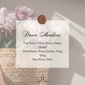 Könnte beinhalten: Eine weiße Karte mit dem Text "Dawn Awakens" in kursiver Schrift. Die Karte listet die Duftnoten auf: Kopfnoten: Zitrus, Pfingstrose, Grün, Kräuter. Herznoten: Blumig, Jasmin, Ylang-Ylang. Basisnoten: Iris.