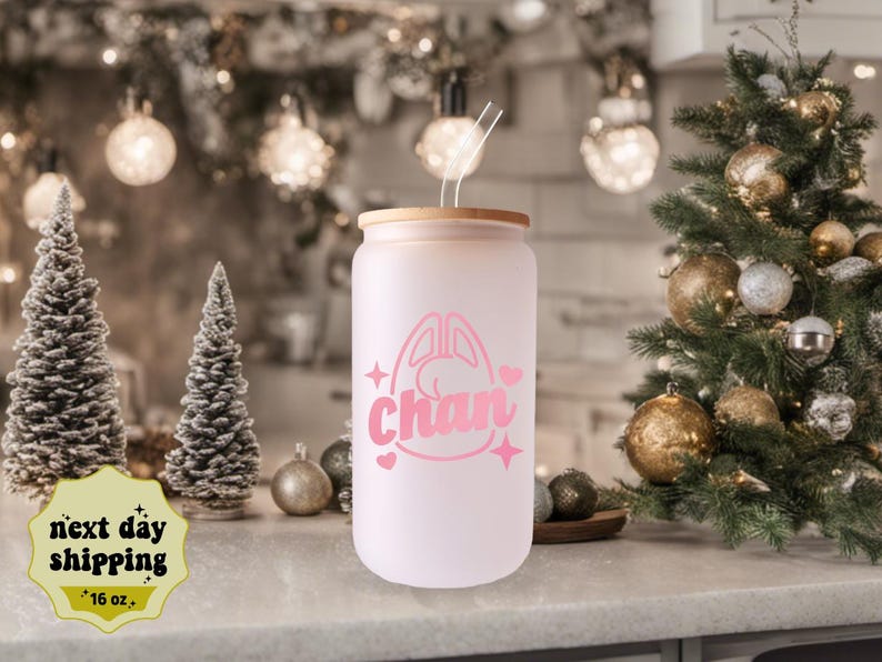 May include: A frosted glass water bottle with a bamboo lid and a pink bunny graphic with the name "Chan" on it. The bottle is 16 ounces.