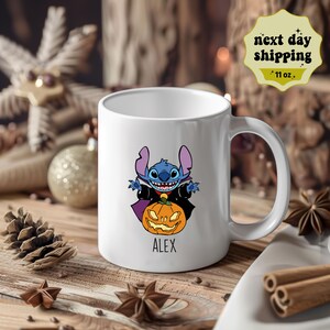May include: White ceramic mug with a blue Stitch character dressed as a vampire holding a jack-o'-lantern. The mug has the name "ALEX" printed on the bottom.
