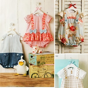May include: Simplicity baby clothing patterns. The image shows several baby rompers and a stuffed duck. The patterns include a pink gingham romper with blue bows, a floral romper, a striped romper, and a tan and white checkered romper.