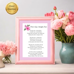 以下が含まれることがあります： ピンク色のフレームに入ったプリントには、「Mom's Love, Heartfelt Poem」というタイトルの詩が描かれています。詩は白い背景に黒いテキストで書かれており、花の模様で飾られています。ピンクの花束が近くに置かれています。