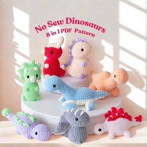 May include: A collection of eight colorful, handmade crochet dinosaur toys. The dinosaurs are in various colors, including red, green, blue, and purple. The text "No Sew Dinosaurs 8 in 1 PDF Pattern" is displayed at the top of the image.