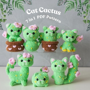 Peut inclure: Collection de sept figurines de cactus chats verts au crochet, avec des accents de fleurs roses et des détails jaunes. Certains sont dans des pots bruns. Le texte "Cat Cactus 7 in 1 PDF Pattern" est inclus.