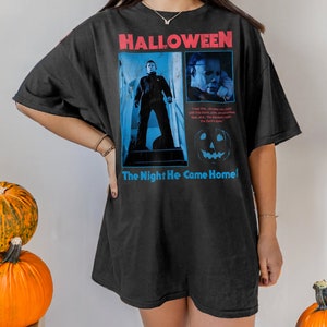 Female model wearing a brown t-shirt featuring a vintage style Michael Myers graphic from the 1978 Halloween movie directerd by horror legend John Carpenter