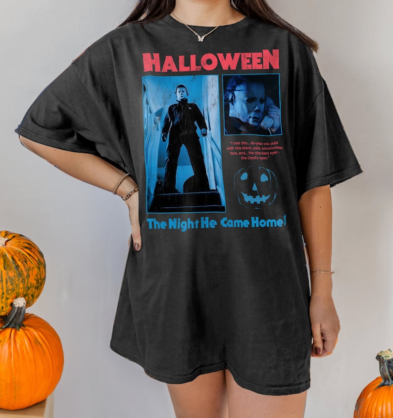Female model wearing a brown t-shirt featuring a vintage style Michael Myers graphic from the 1978 Halloween movie directerd by horror legend John Carpenter