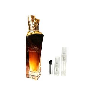 May include: A perfume bottle with a gold-colored, ornate top and a gradient brown to yellow body. The words "Vanilla Seduction" are printed on the front. Three small sample bottles and a dropper are next to the perfume bottle.