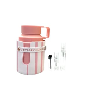 May include: A pink and white striped perfume bottle with a handle and the text "ODYSSEY CANDEE". Several small, clear perfume sample vials are next to the bottle.