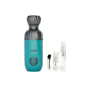 May include: A teal-colored perfume bottle with a gray cap and the text "FIG HUG". The bottle is accompanied by several small, clear sample vials. The design includes a circular emblem with text and a floral pattern.