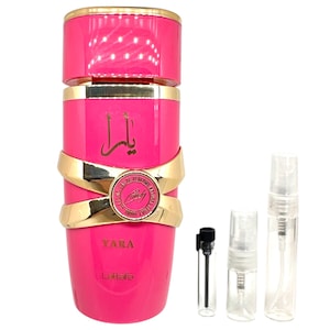 May include: A pink and gold bottle of Yara perfume by Lattafa. The bottle has a gold band with a circular design and the word "Yara" printed on it. The bottle is surrounded by three small glass perfume sample bottles.