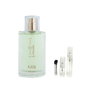 May include: A clear glass perfume bottle with a gold cap and a light green liquid inside. The bottle is labeled "One in a Million Pistachio" and includes 50 ml. Also included are three small sample vials.