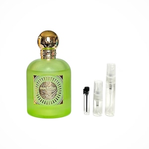 May include: A green glass bottle of perfume with a gold cap and a gold label that says "Solar Potion". The bottle is surrounded by three small clear glass bottles with atomizers.