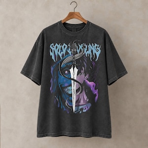 May include: A charcoal grey short-sleeve t-shirt featuring a graphic print of a split-faced character with a sword in the center. The text "SOLO LEVELING" is printed in a light blue stylized font above the character illustration on the front.