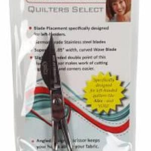 May include: Left-handed wave appliqué scissors with a silver blade and black handles. The scissors are designed for quilting and feature a curved wave blade. The packaging includes the text "Left-Handed Edition" and "Quilters Select".