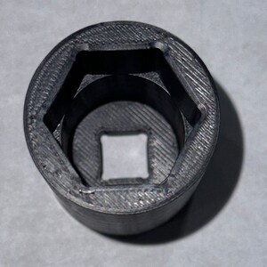 May include: A black plastic socket wrench with a hexagonal opening.