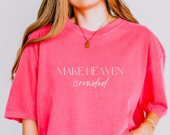 Op de afbeelding: Een oversized roze T-shirt met de tekst "MAKE HEAVEN crowded" in witte letters.