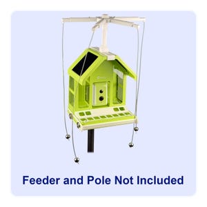 May include: A lime green bird feeder with a house-like design, featuring a black solar panel roof and a white base. The feeder has a series of small openings and is suspended by wires with silver ball weights. The text "Feeder and Pole Not Included" is at the bottom.
