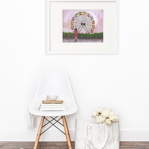 May include: A framed illustration of a girl standing in front of a large Ferris wheel with a pink sky in the background.