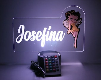 May include: A white acrylic night light with the name "Josefina" and a cartoon angel with a halo. The light has a remote control with multiple colored lights.