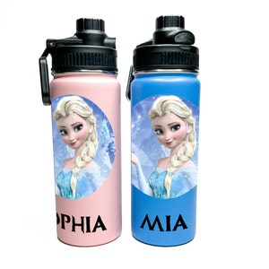 Puede incluir: Dos botellas de agua de acero inoxidable con un diseño de personaje de Frozen. La botella de la izquierda es rosa con el nombre "Sophia" y la botella de la derecha es azul con el nombre "Mia".