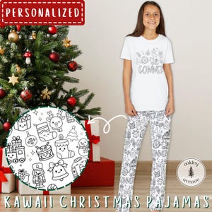 May include: White Kawaii Christmas pajamas set with a matching t-shirt and pants. The t-shirt has a graphic design and the word "COMMER" printed on it. The pants feature a repeating pattern of Christmas-themed Kawaii illustrations. The pajamas are displayed near a decorated Christmas tree.