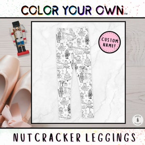 May include: White leggings with a black and white Nutcracker-themed print, featuring illustrations of ballerinas, nutcrackers, and Christmas trees. The leggings have a customizable name tag. The words "COLOR YOUR OWN" and "NUTCRACKER LEGGINGS" are also visible.