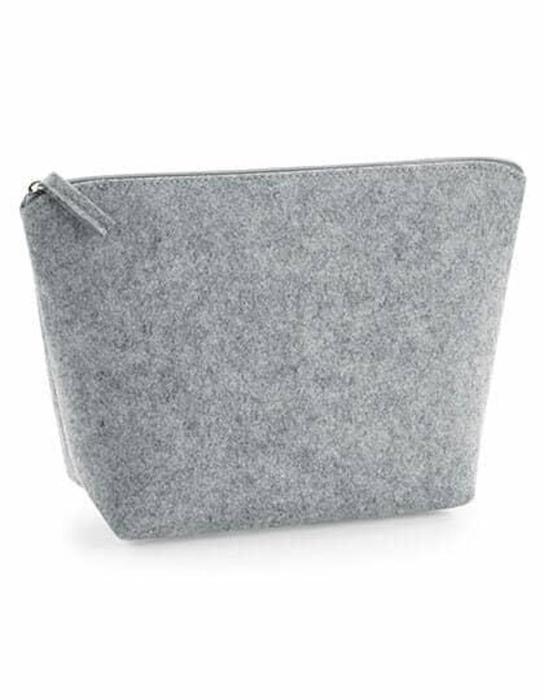 May include: A gray felt zippered pouch. The pouch is rectangular with a trapezoidal shape, wider at the base and tapering towards the top. The zipper pull is a small tab of the same gray felt material.
