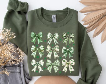 May include: A green sweatshirt with a pattern of green and white shamrock bows. The bows are arranged in a grid pattern on the front of the sweatshirt.