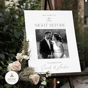 May include: A white welcome sign with black text that reads "Welcome to the Night Before Celebrating Sarah & Andrew". A black and white photo of a couple is in the center of the sign.