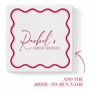 Puede incluir: Una baldosa cuadrada blanca con un borde rojo ondulado de doble l&iacute;nea. El texto "Rachel's BRIDAL SHOWER" est&aacute; escrito en una fuente roja cursiva. La esquina inferior derecha tiene una flecha que apunta al texto "ADD THE BRIDE-TO-BE'S NAME".